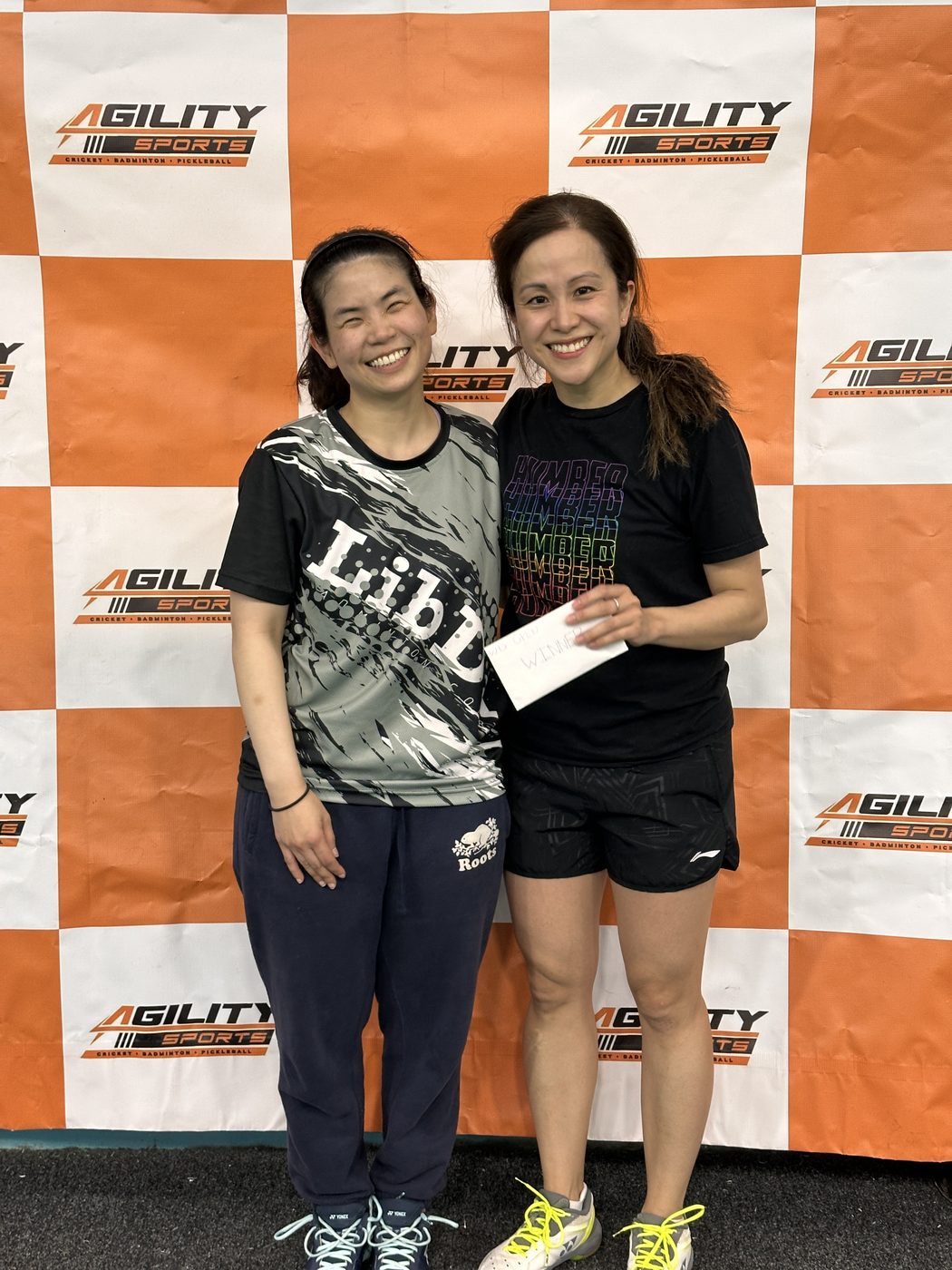 Two players share a smile at a tournament medal presentation